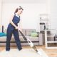female cleaner vacuuming carpet in home