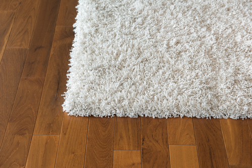 close up image of hard wood floor and white carpet