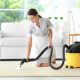 cleaning woman with apron professionally cleaning carpet in modern home